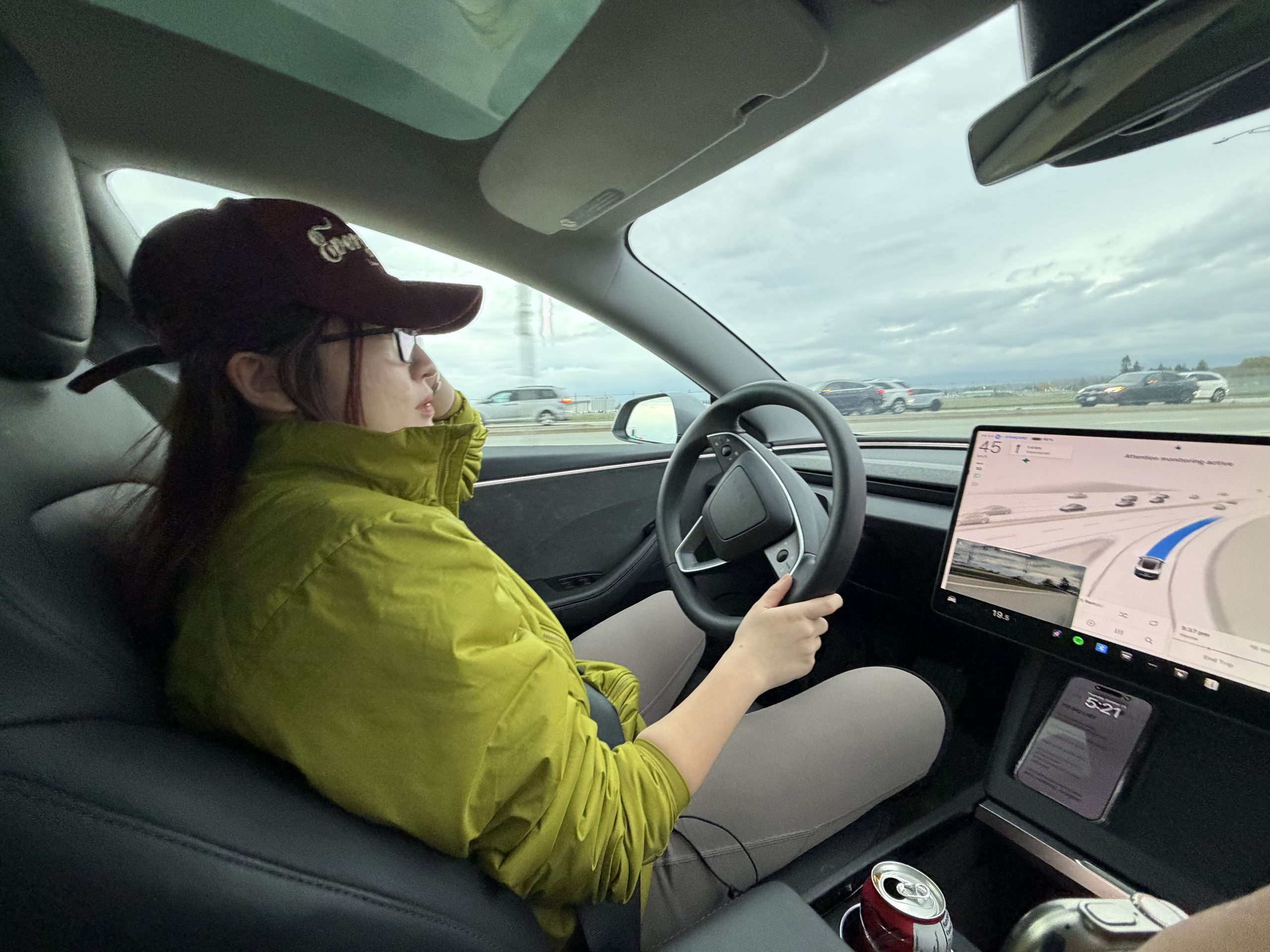 Yana Song working remotely on laptop inside a car, digital nomad lifestyle